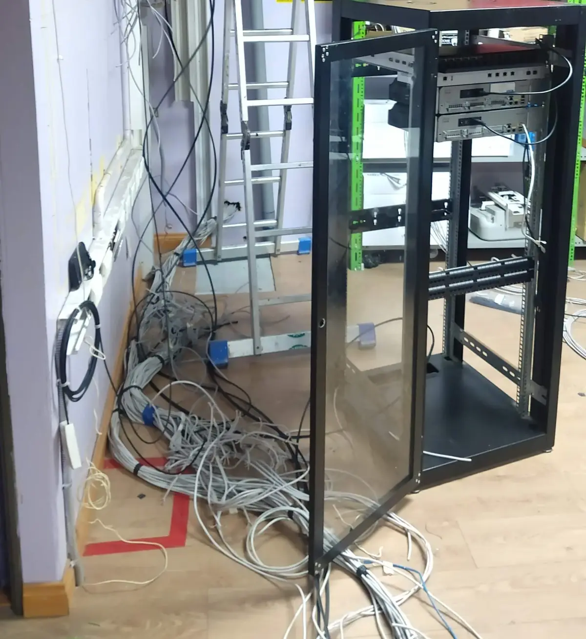Router doméstico y cables enredados bajo un escritorio de oficina