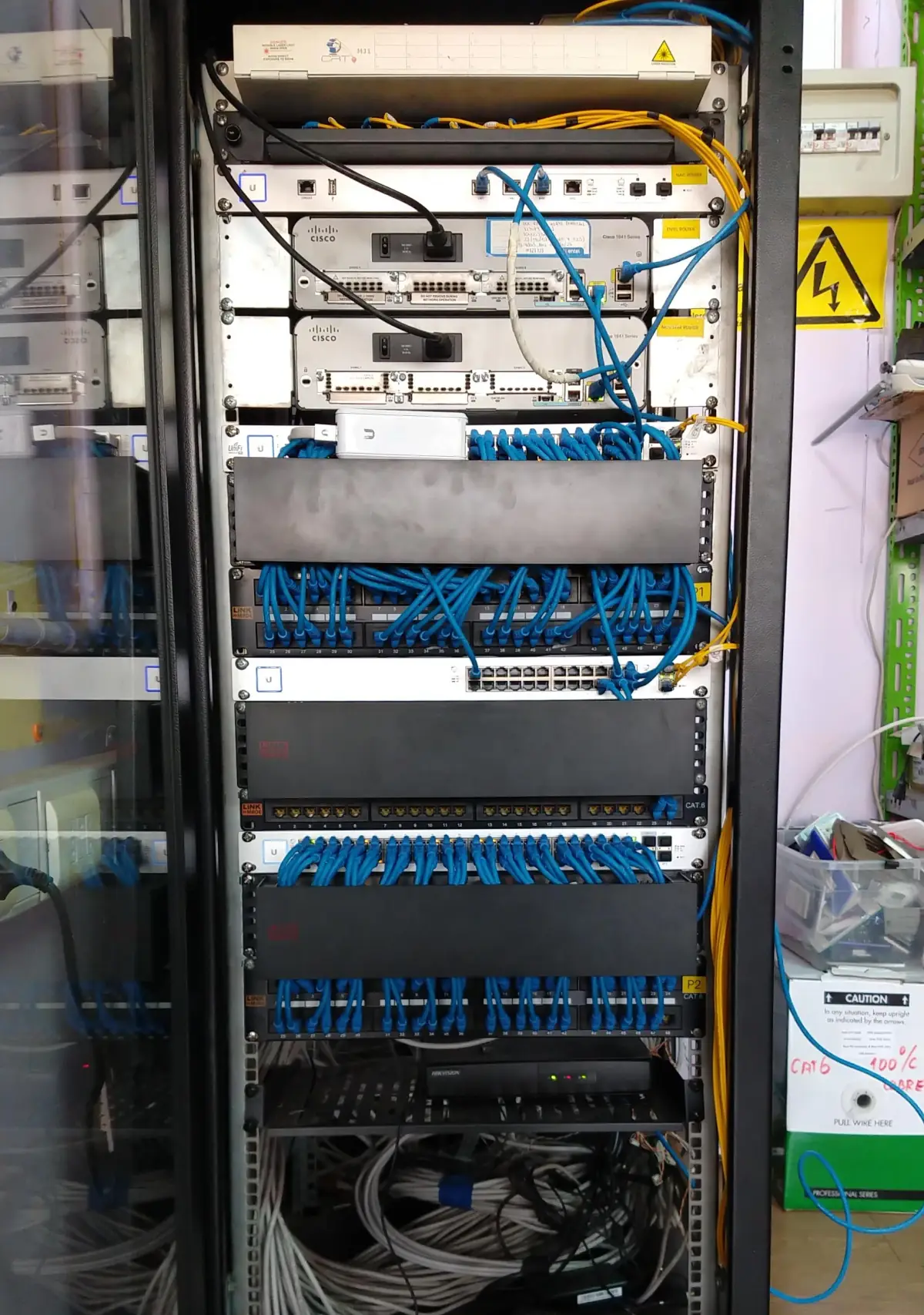 Rack de pared con patch panel y cables de red ordenados con velcro